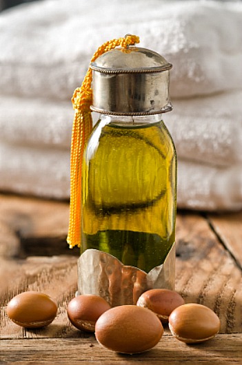 glass bottle of Argan oil and Argan seeds, used for cosmetic products